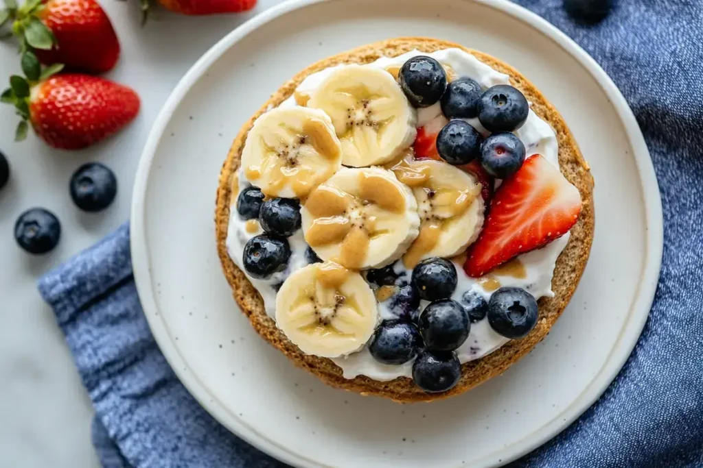 Healthy blueberry bagel topped with Greek yogurt and banana slices.